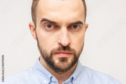 Doubting man stares into camera, portrait, close-up, cropped image