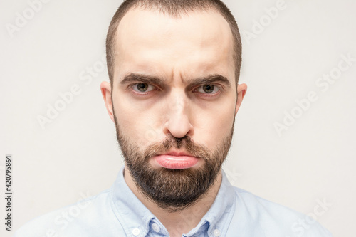 Frustrated bearded man, man pouted his lips out of resentment, sad face of the bearded man, close-up