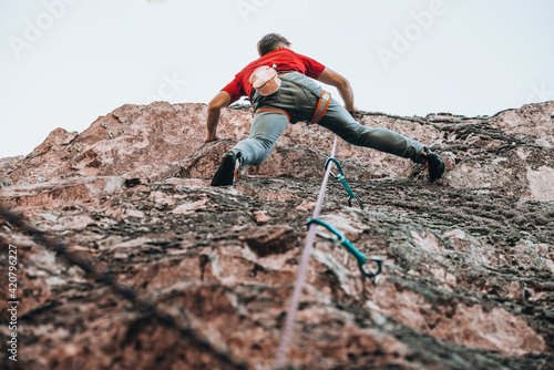 Climber with climbing equipment hanging on a rope