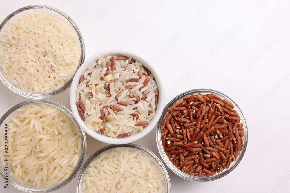Long grain basmati medium grain jasmine short grain pilaf polau risotto brown low glycaemic index gi rice in small glass bowl on white background copy text space top flat lay view Long grain basmati medium grain jasmine short grain pilaf polau risotto brown low glycaemic index gi rice in small glass bowl on white background copy text space top flat lay view