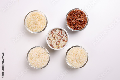 Long grain basmati medium grain jasmine short grain pilaf polau risotto brown low glycaemic index gi rice in small glass bowl on white background copy text space top flat lay view