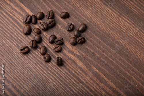 Roasted coffee beans on a wooden background.Top view