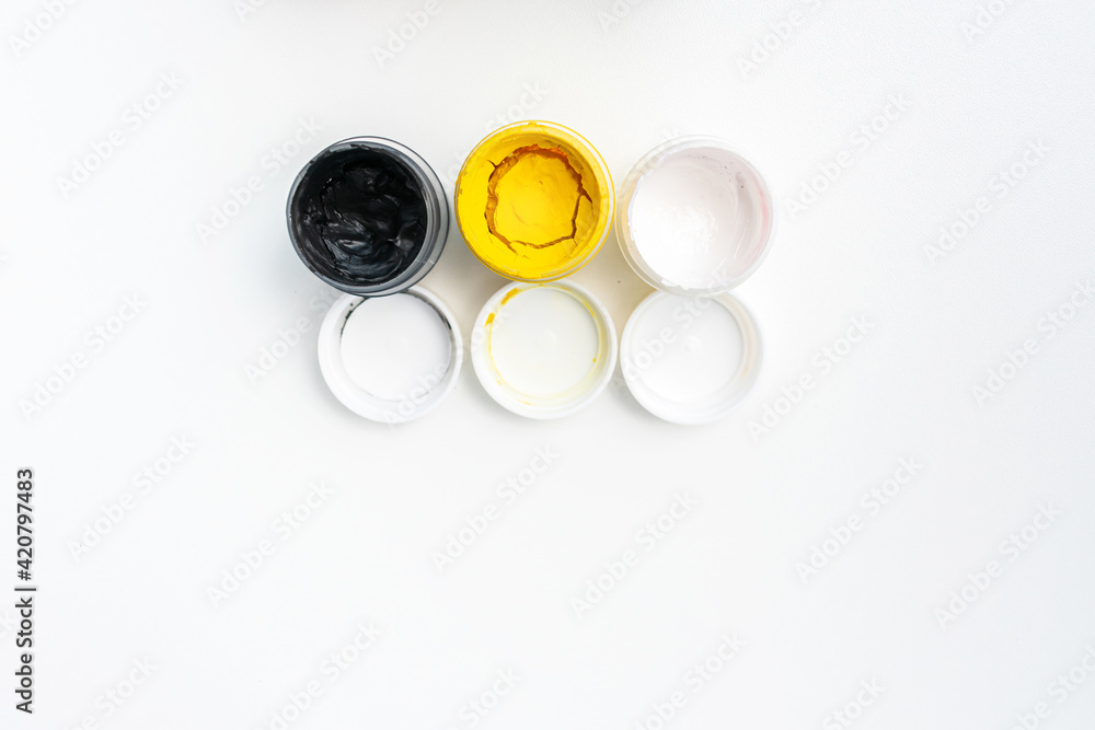 Cans of different colors gouache paints, top view, closeup, white background, copy space Cans of different colors gouache paints, top view, closeup, white background, copy space
