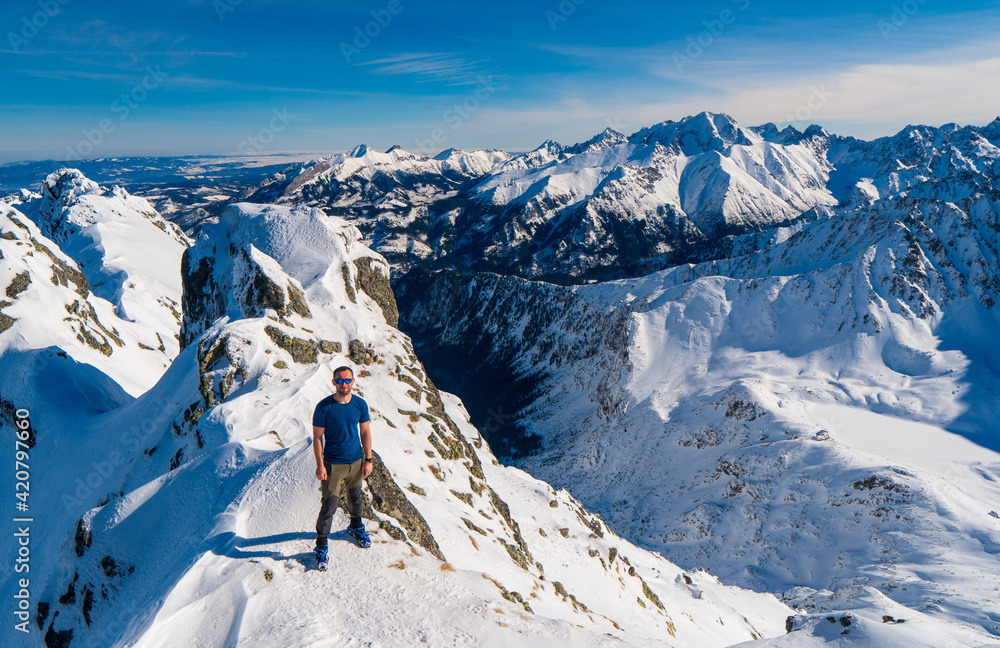 Obraz premium Climber looking at a snowy mountain landscape in a sunny winter day..