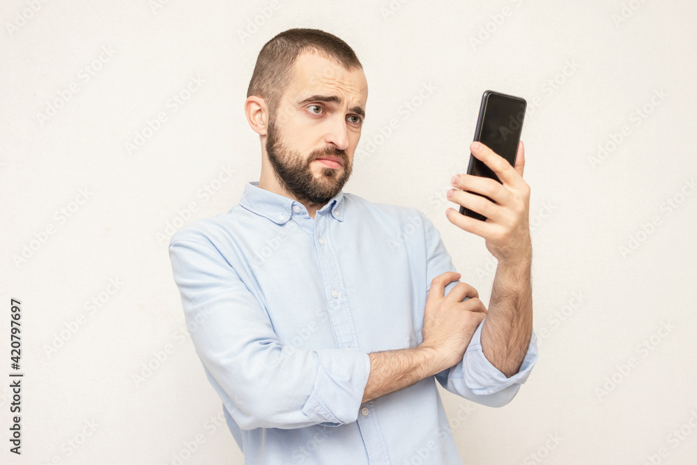 Displeased man with a phone, portrait, white background