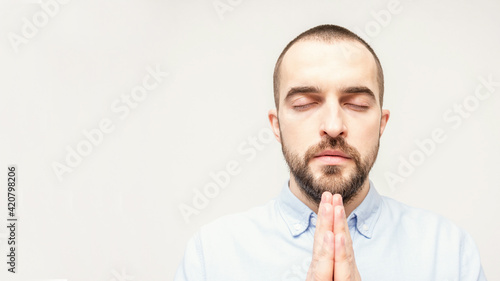 Religious bearded Baptist praying, man folded his hands in prayer, portrait, close-up, white background, copy space, 16:9