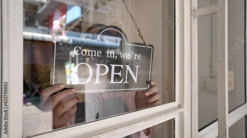 Cafe owner flipping sign to close shop. photo