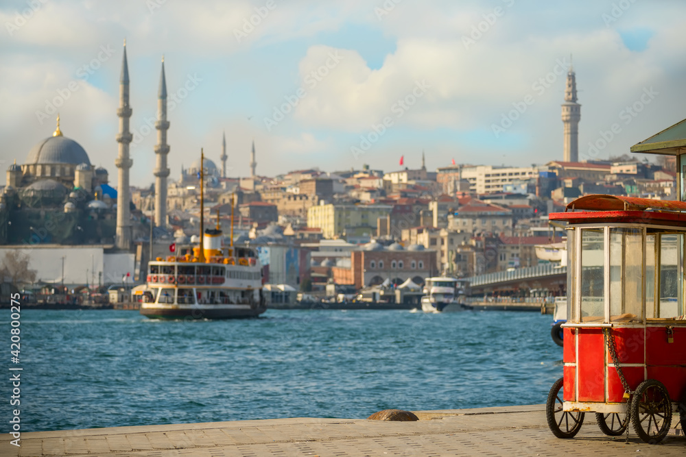 Naklejka premium View of the Bosphorus and the old town on a sunny day. An old traditional merchant cart at the wharf. Istanbul. Turkey 