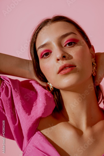 Fototapeta Close up beauty portrait of young beautiful woman with pink, fuchsia color eyeshadow makeup, flawless clean skin