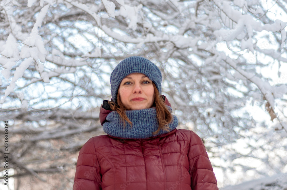 Winter portrait of a girl. Girl in warm clothes. Portrait of a woman in a winter park. Winter portrait of a girl. Girl in warm clothes. Portrait of a woman in a winter park.