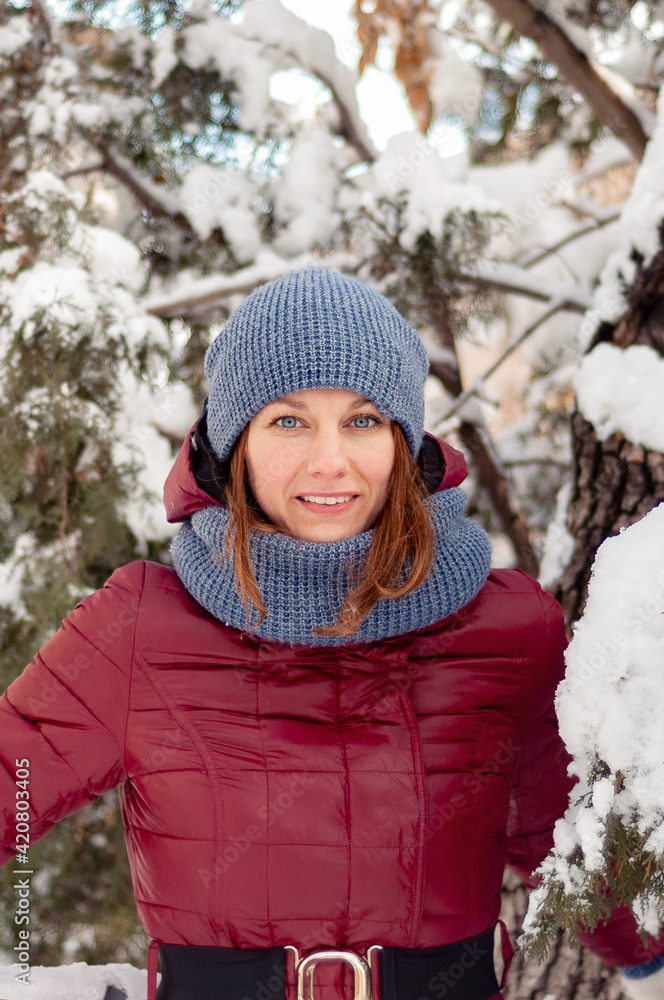 Winter portrait of a girl. Girl in warm clothes. Portrait of a woman in a winter park. Winter portrait of a girl. Girl in warm clothes. Portrait of a woman in a winter park.