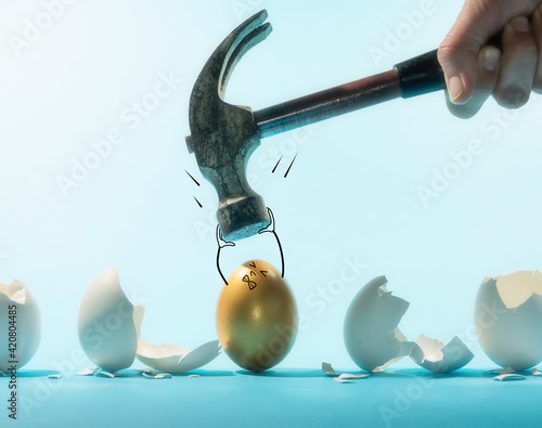 Картината върху платно Intact golden egg holds the hammer among broken white eggs