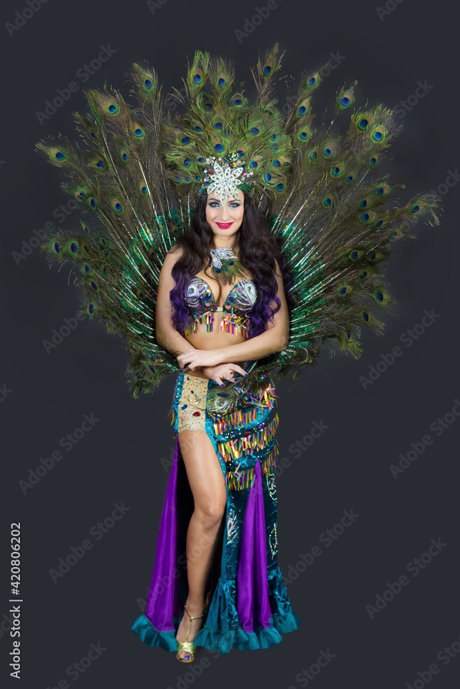 National dancer in a luxurious outfit of bird feathers on a black background isolated. National dancer in a luxurious outfit of bird feathers on a black background isolated.