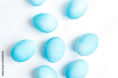 Happy Easter concept. Chicken eggs painted in blue color in the egg compartment. Preparation for holiday. White background copy space