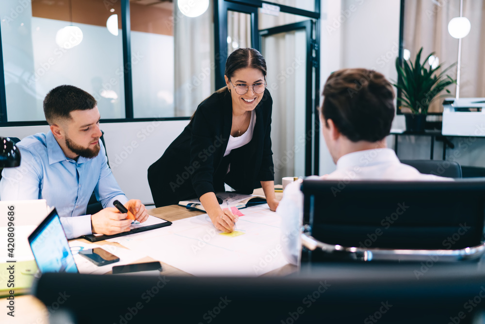 Positive young colleagues developing business strategy in workspace Positive young colleagues developing business strategy in workspace