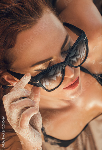 Fashion close up portrait of young female model posing in modern sunglasses 
