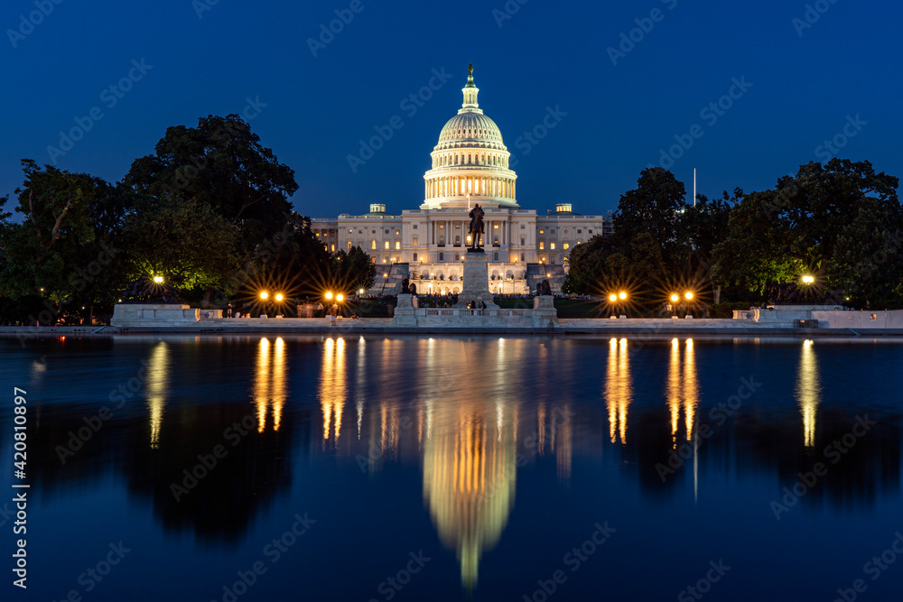 Capitol hill building at night illuminated with light with lake reflection Washington DC.