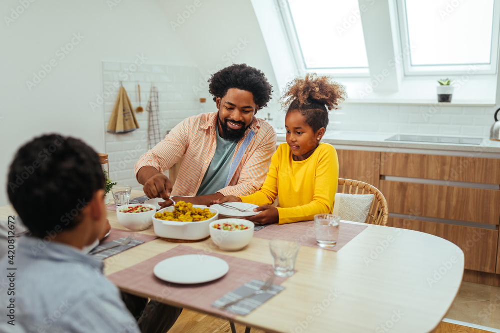 Cute afro family having lunch together at home