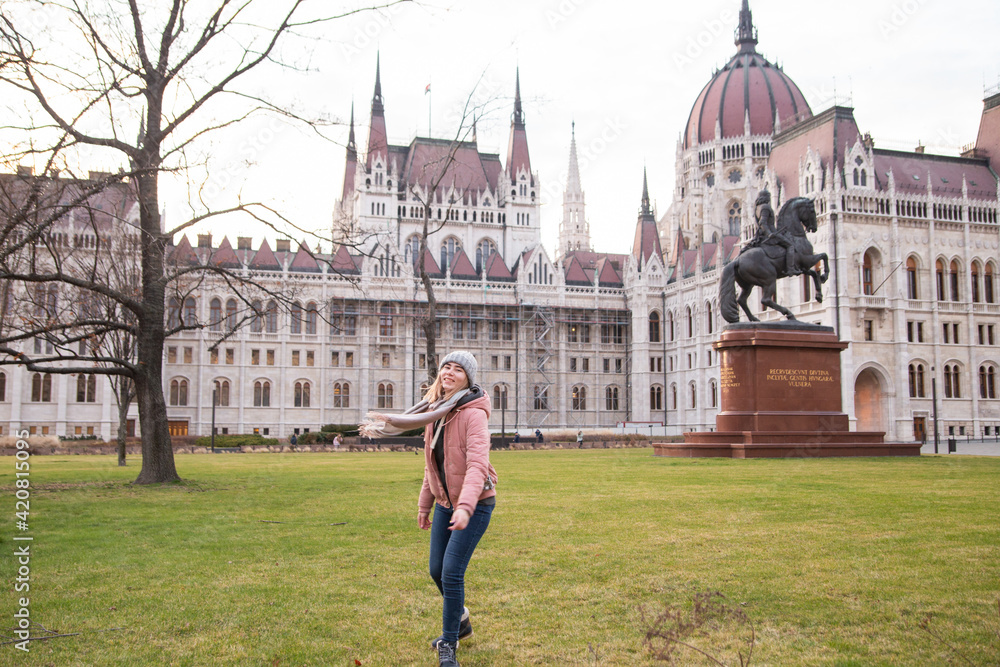 Fototapeta premium Tourist - a girl travels around Europe. Travel to Hungary, European tour.A girl near the Hungarian parliament.