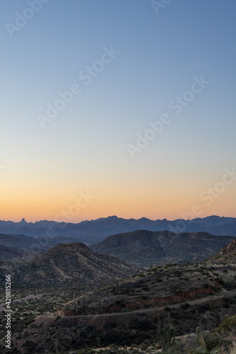 Orange and blue Arizona sunset behind mountains 