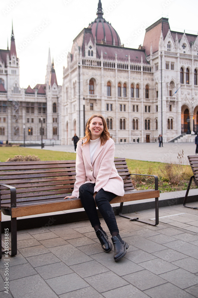 Obraz premium Tourist - a girl travels around Europe. Travel to Hungary, European tour.A girl near the Hungarian parliament.