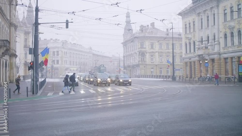 Cluj / Romania - March 2021: Pedestrians crossing the street. Wearing masks. Pandemic safety measures. 