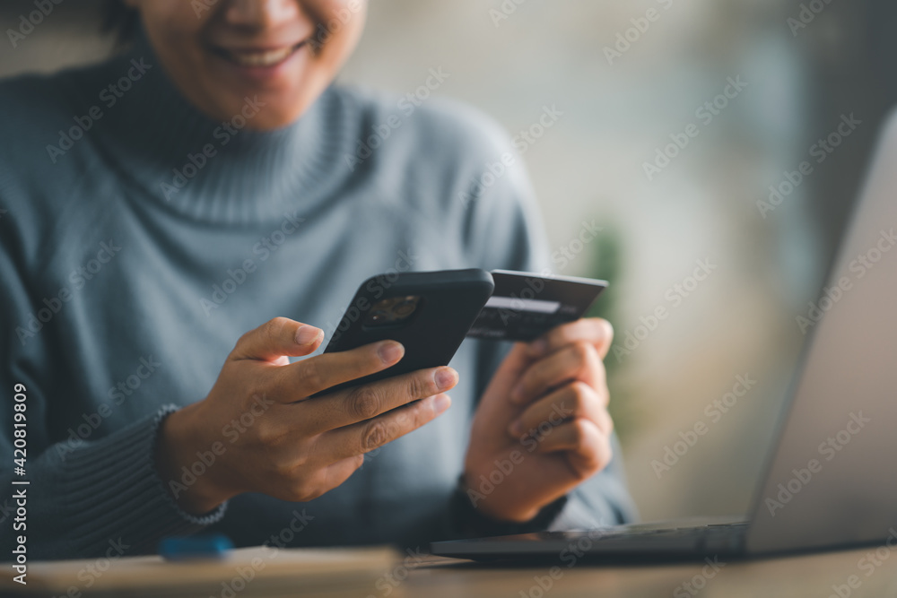 woman makes a purchase on the Internet on the smart phone with credit card, online payment, shopping online, e-commerce, internet banking, spending money