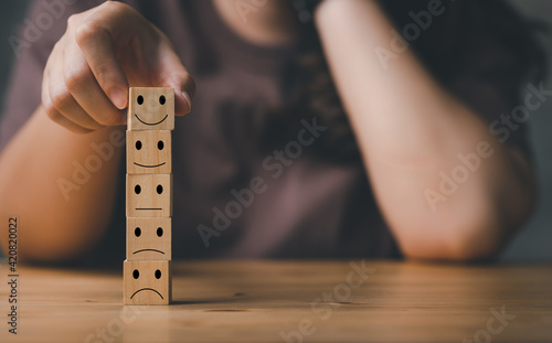 best excellent business services rating customer experience. Satisfaction survey concept. Hand of a woman chooses a smiley face on wood block cube.