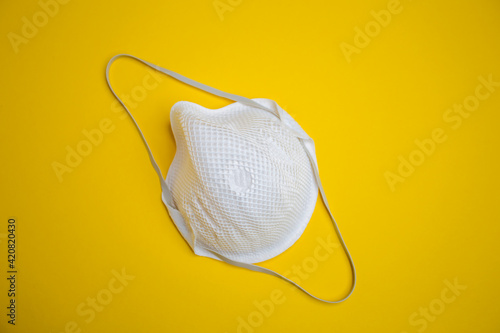 ffp2 mask with a rubber band on a yellow background.