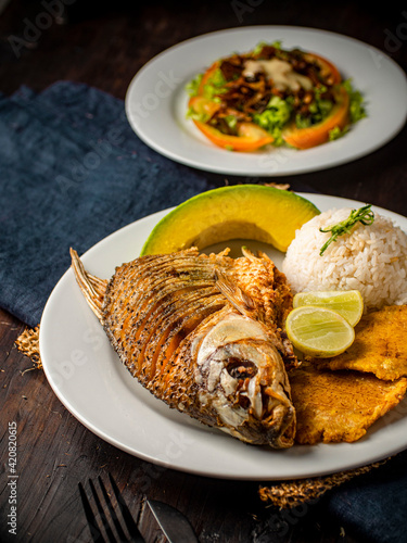 pescado frito con arroz patacones y aguacate photo