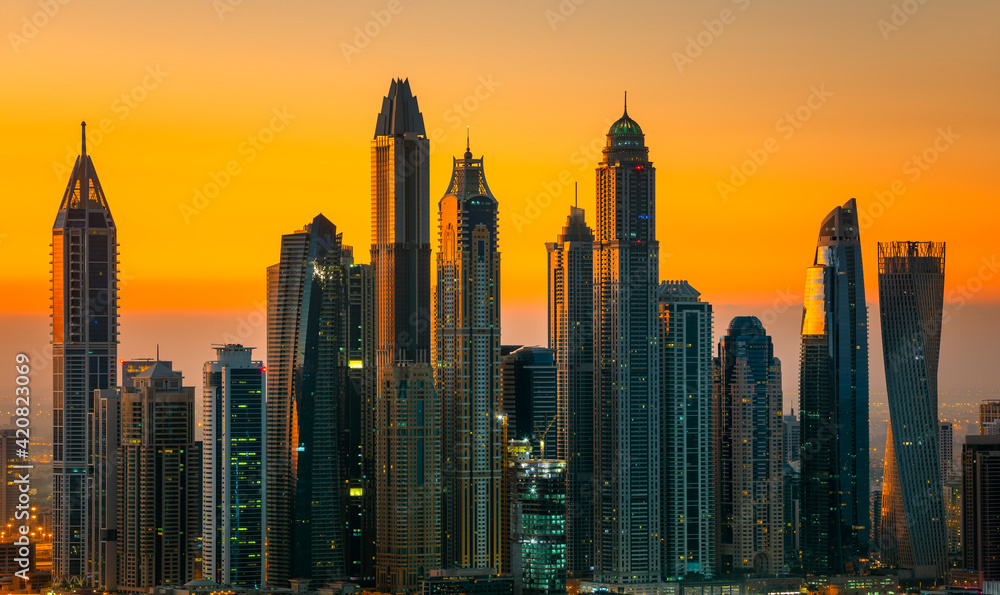 DUBAI, UNITED ARAB EMIRATES - MARCH 10, 2016: People relaxing on Jumeirah beach in Dubai Marina luxury hotels,United Arab Emirates