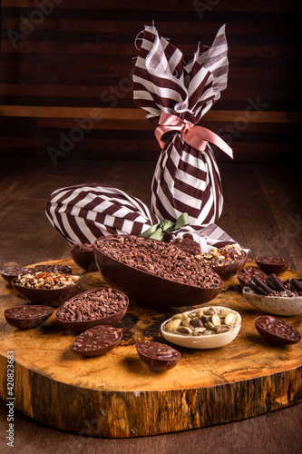 Sticker Stuffed chocolate easter egg with grated chocolate on the top and lots of mini stuffed easter eggs all around it on a tree trunk