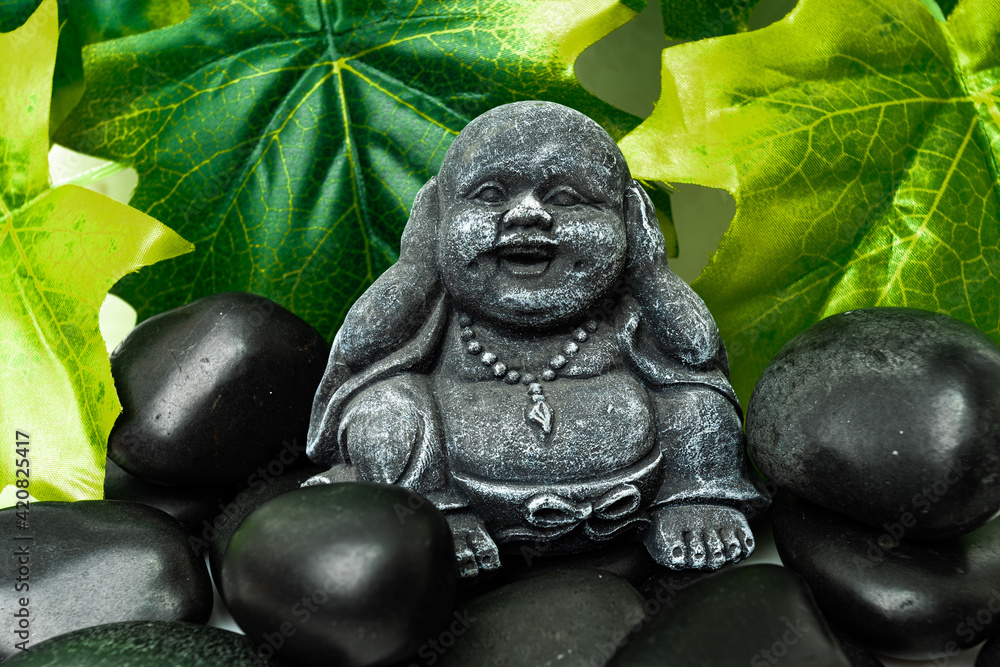Obraz premium Buddha and stack of black basalt stones