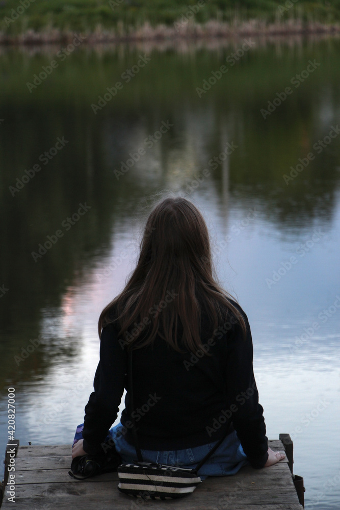 a girl on a wooden bridge by the water a girl on a wooden bridge by the water