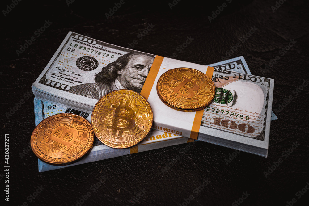 Fototapeta premium golden bitcoin metal coin on one US dollar bill