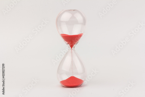 Crystal hourglass on light background as a concept of passing time for business term, urgency and outcome of time.