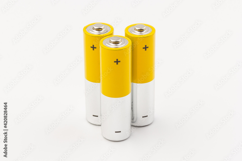 Photo of gray-yellow alkaline AA batteries on white background. Recycling of rechargeable NiMH batteries. The most popular size of accumulators. Copy space. Photo of gray-yellow alkaline AA batteries on white background. Recycling of rechargeable NiMH batteries. The most popular size of accumulators. Copy space.