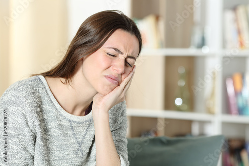 Woman suffering toothache at home
