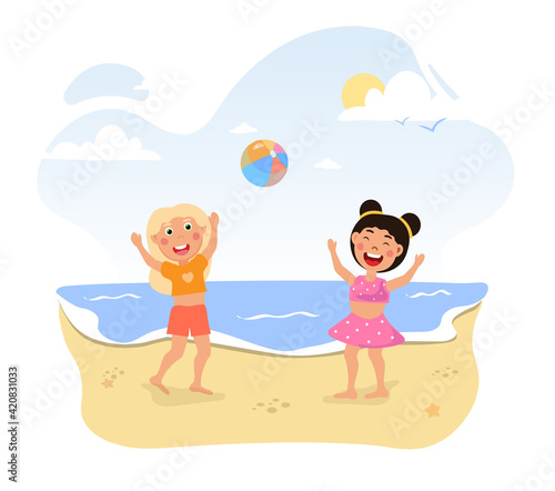 Two happy little girls are playing with ball at the beach