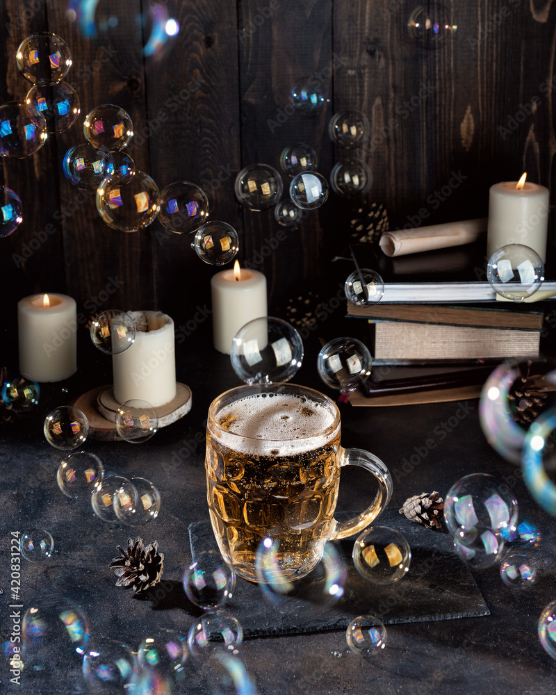 Pint of magic beer and candles on a dark bar counter