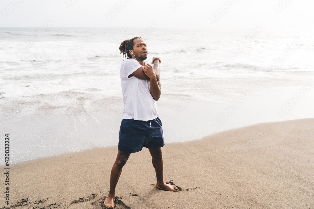 Black man stretching arms on beach Black man stretching arms on beach