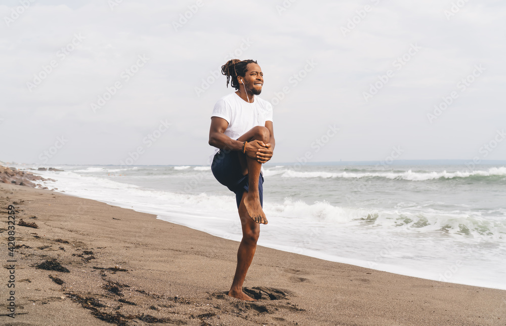 Black man doing exercises on beach