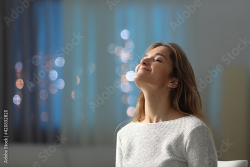 Satisfied tenant breathing fresh air in the night at home photo