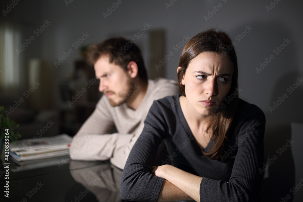 Angry couple ignoring each other at home in the night Angry couple ignoring each other at home in the night
