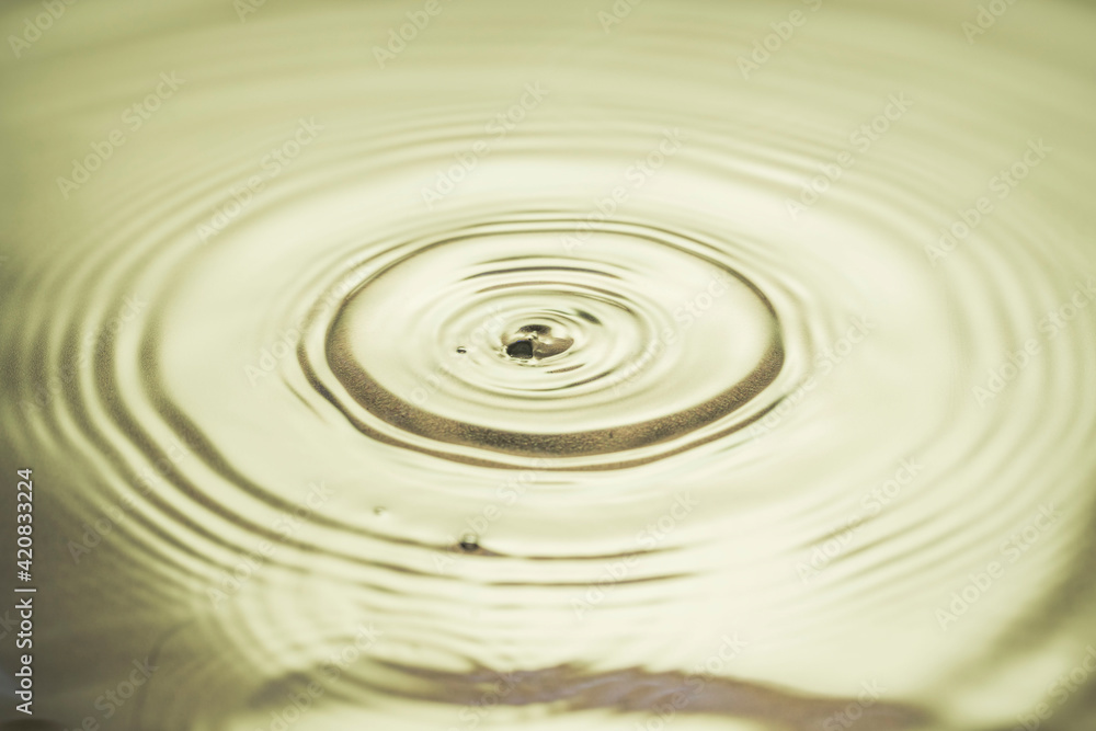 Close up view of drops making circles on water surface isolated on background. Close up view of drops making circles on water surface isolated on background.