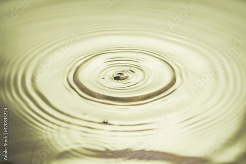 Close up view of drops making circles on water surface isolated on background.