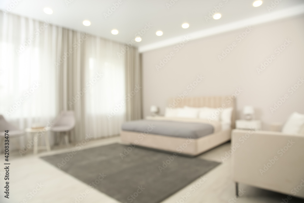 Fototapeta premium Blurred view of beautiful hotel room interior with double bed