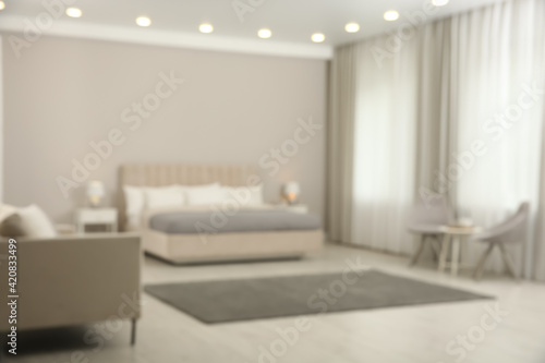 Blurred view of beautiful hotel room interior with double bed