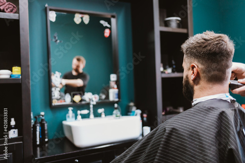 Bearded man getting haircut in barbershop