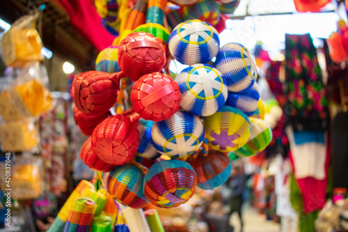 Colorful handmade rattles hanging inside a Mexican market